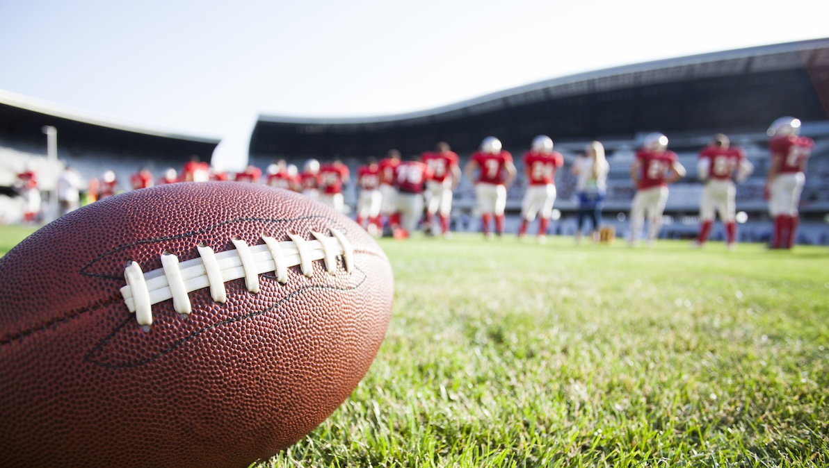 A close-up shot of a football one of many football stadiums with real grass.